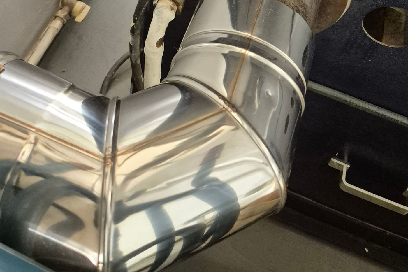 Raccordement d’un coude d’extraction en inox sur la hotte d’un torréfacteur